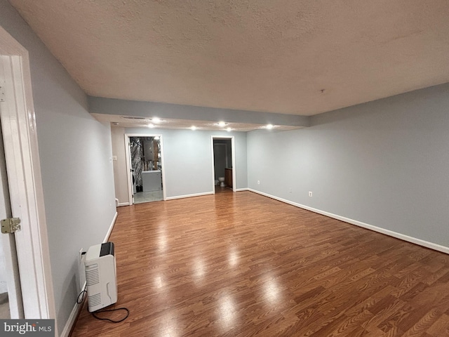 interior space with wood finished floors, baseboards, and a textured ceiling