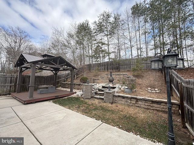 view of yard featuring a gazebo, a patio area, a wooden deck, and a fenced backyard