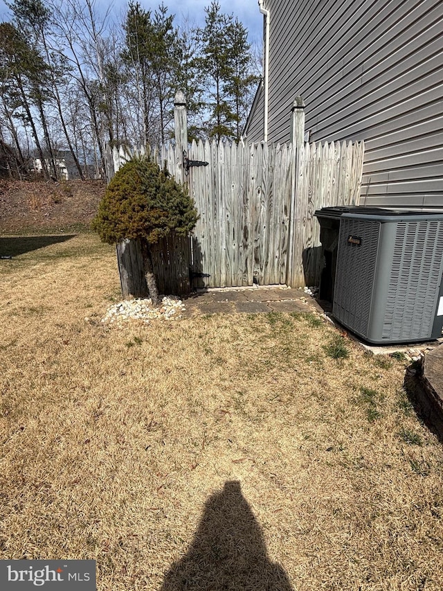 view of yard with central AC unit and fence