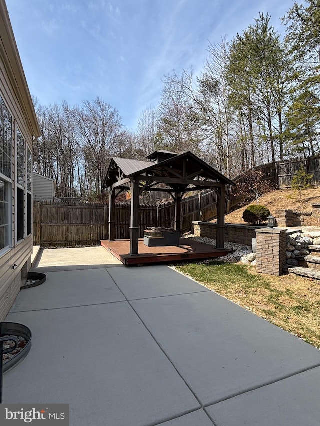 view of patio / terrace with a gazebo, a wooden deck, and a fenced backyard