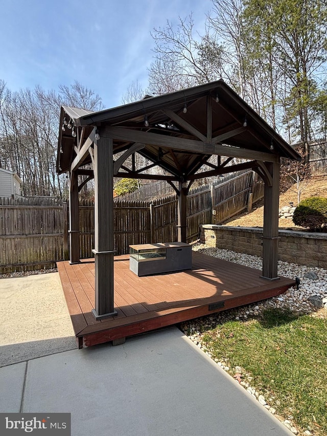 wooden terrace with a gazebo and a fenced backyard