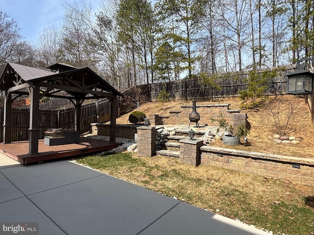 view of yard featuring a gazebo, a wooden deck, a patio, and a fenced backyard