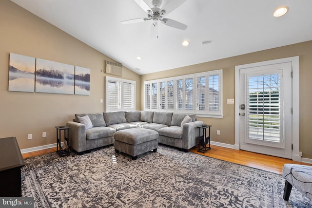 living room with wood finished floors, baseboards, and vaulted ceiling