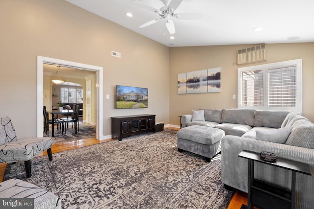 living room with recessed lighting, baseboards, wood finished floors, and vaulted ceiling