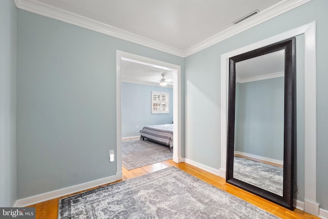 bedroom with visible vents, ornamental molding, baseboards, and wood finished floors