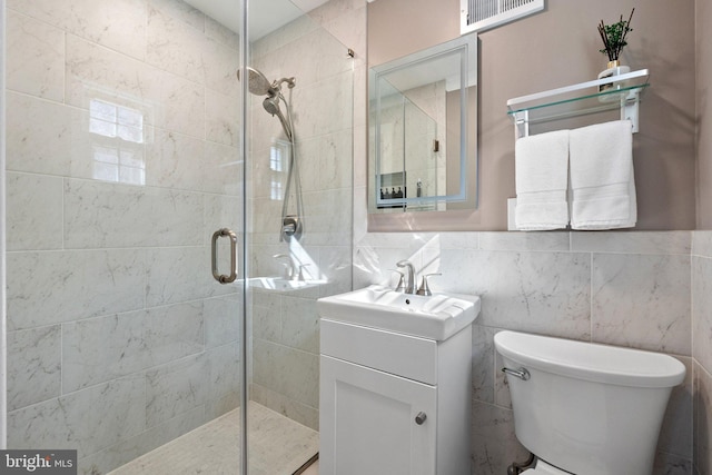 bathroom with visible vents, tile walls, toilet, a stall shower, and vanity