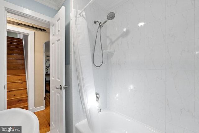 bathroom with crown molding, wood finished floors, and shower / bath combo with shower curtain