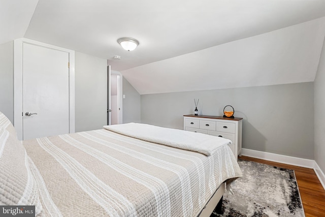 bedroom featuring vaulted ceiling, baseboards, and wood finished floors