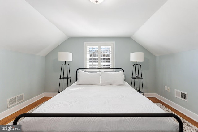 bedroom with wood finished floors, baseboards, and visible vents