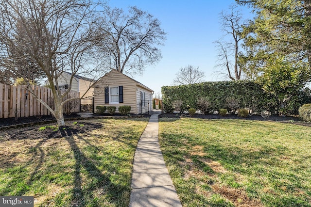 view of front of property featuring a gate, a front lawn, and fence