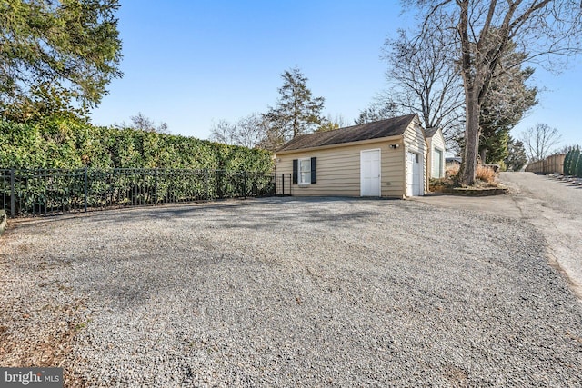 garage featuring driveway and fence