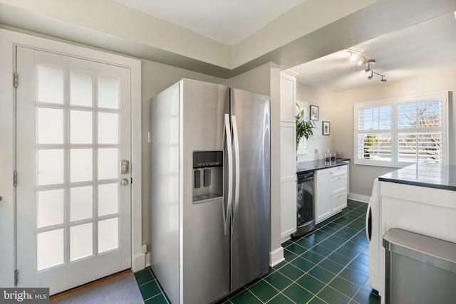 kitchen featuring dark tile patterned flooring, stainless steel refrigerator with ice dispenser, dark countertops, white cabinets, and baseboards