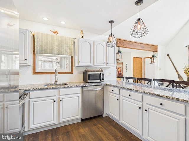kitchen with a sink, tasteful backsplash, white cabinetry, stainless steel appliances, and dark wood-style flooring