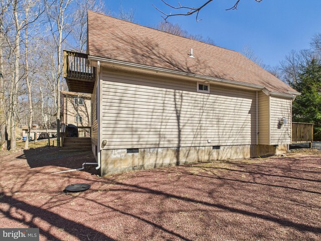 view of side of property featuring crawl space, a shingled roof, and a balcony