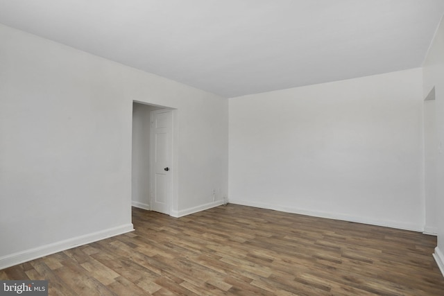 unfurnished room featuring baseboards and wood finished floors