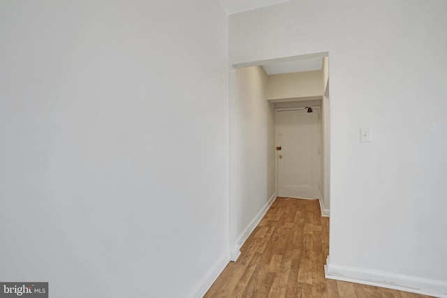 hall featuring baseboards and light wood-type flooring