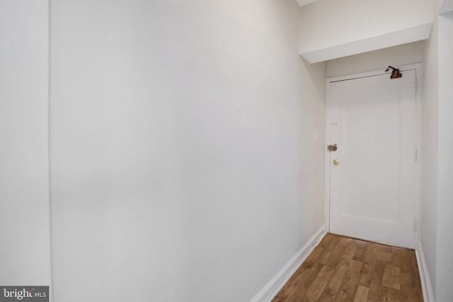 hallway with baseboards and wood finished floors