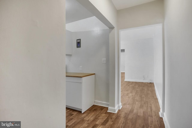 hallway featuring baseboards and wood finished floors