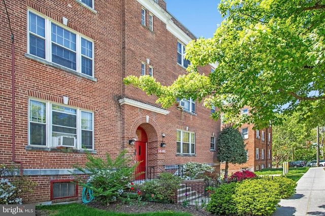 view of property featuring cooling unit and brick siding