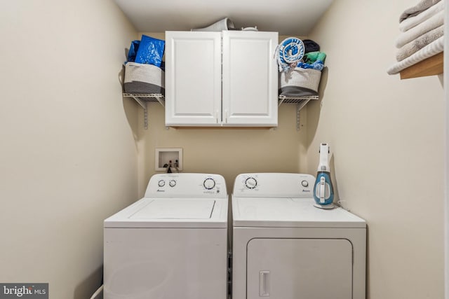 washroom with cabinet space and washer and dryer