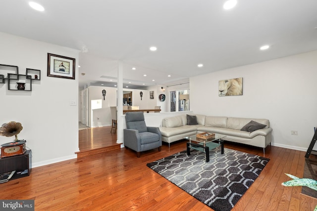 living area featuring recessed lighting, baseboards, and wood-type flooring