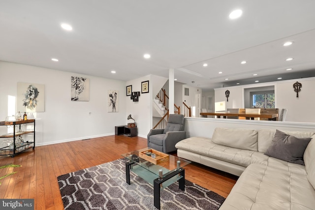 living room featuring recessed lighting, stairs, baseboards, and hardwood / wood-style floors