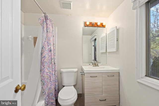 bathroom with vanity, toilet, shower / bath combo, and visible vents