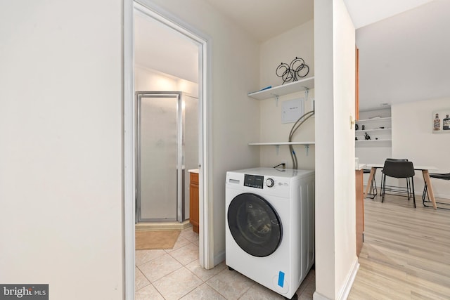 laundry area with laundry area, washer / clothes dryer, and light wood-type flooring