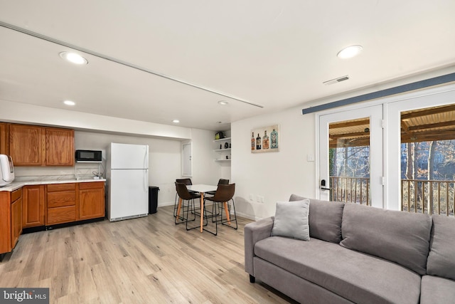 living room with visible vents, recessed lighting, light wood-type flooring, and baseboards