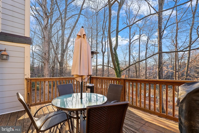 wooden deck featuring outdoor dining area and a grill