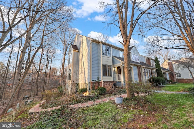 view of side of home featuring brick siding and a yard