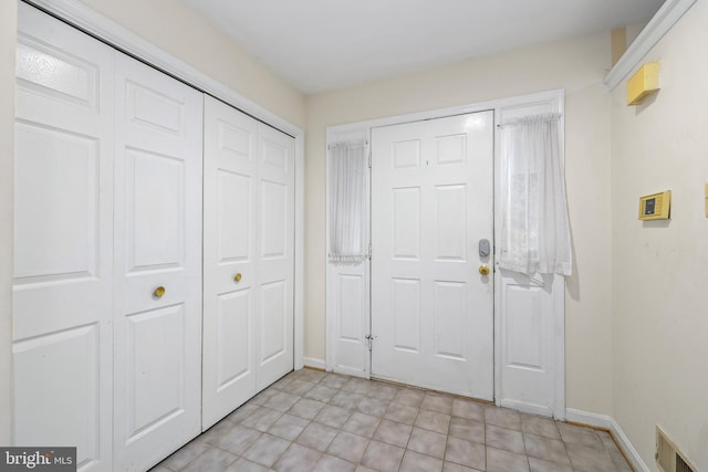 foyer entrance featuring baseboards and visible vents