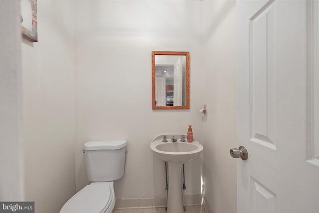 bathroom with baseboards and toilet