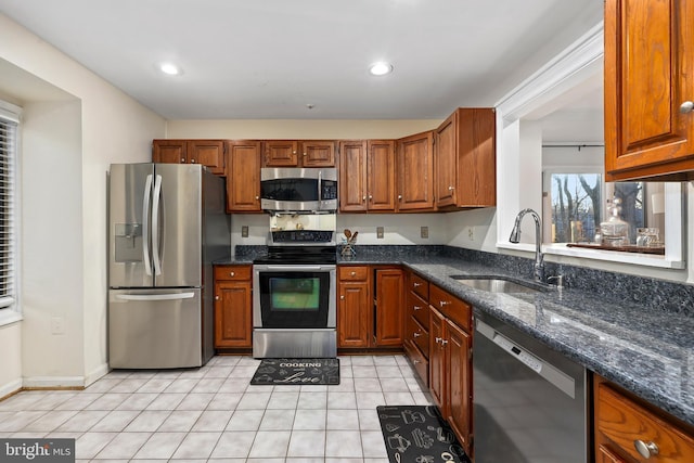 kitchen featuring brown cabinetry, appliances with stainless steel finishes, and a sink