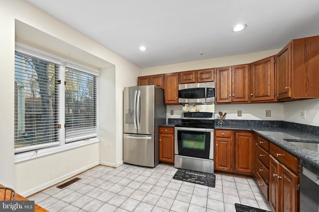 kitchen featuring visible vents, light tile patterned flooring, recessed lighting, stainless steel appliances, and brown cabinets