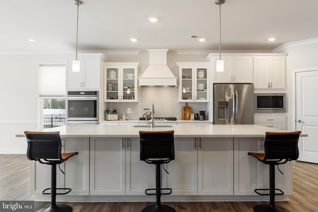 kitchen with visible vents, a large island, custom range hood, appliances with stainless steel finishes, and decorative backsplash