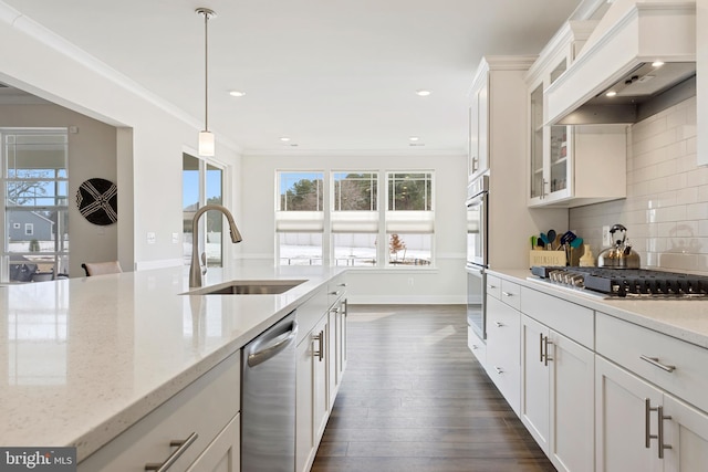 kitchen featuring custom exhaust hood, ornamental molding, appliances with stainless steel finishes, and a sink