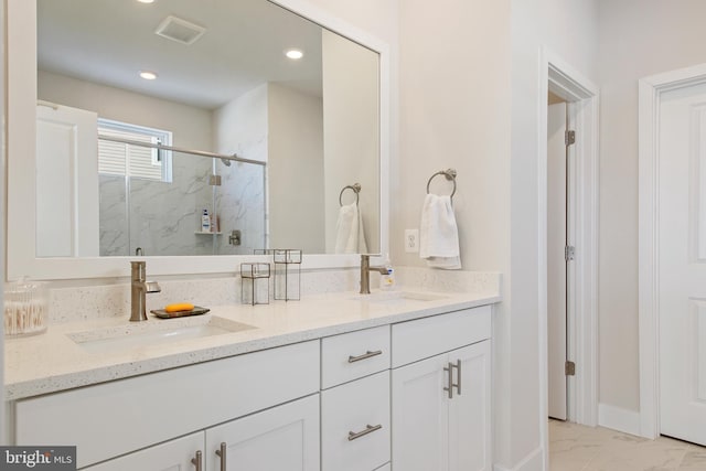 bathroom with a sink, a marble finish shower, marble finish floor, and visible vents