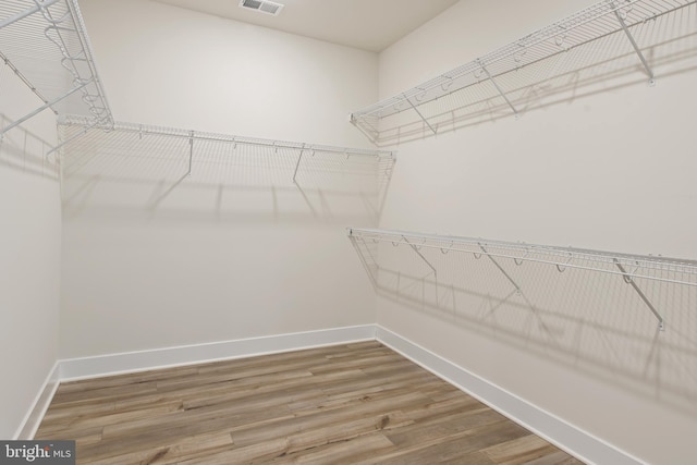 spacious closet featuring visible vents and wood finished floors