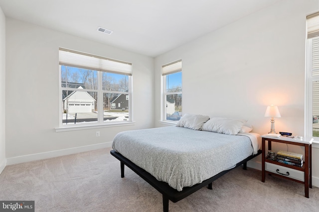 carpeted bedroom featuring visible vents and baseboards