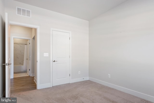 unfurnished bedroom featuring visible vents, carpet floors, and baseboards