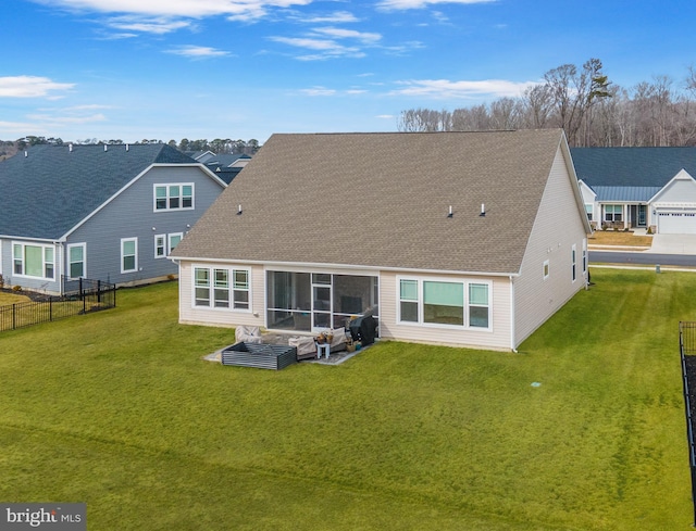 back of property featuring a yard, a shingled roof, and fence