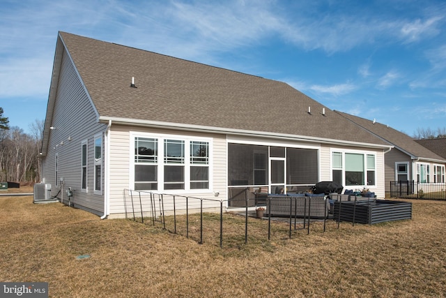 rear view of property with a yard, central air condition unit, a shingled roof, and an outdoor hangout area