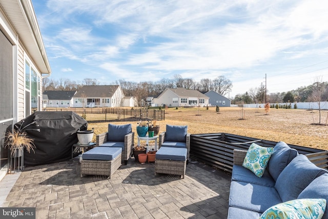 view of patio featuring a grill, a fenced backyard, a residential view, and an outdoor hangout area