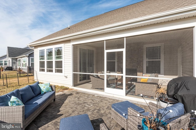 back of house featuring fence, an outdoor living space, a sunroom, a shingled roof, and a patio area