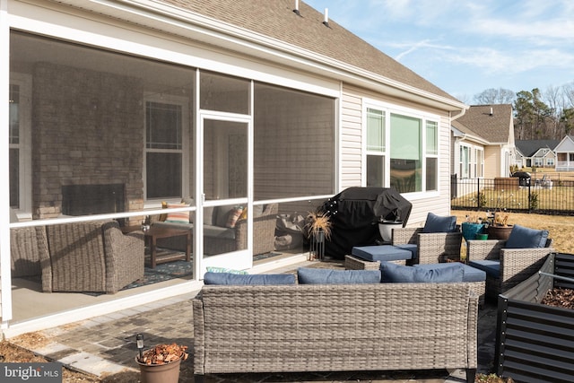 exterior space featuring a grill, fence, a sunroom, and an outdoor hangout area