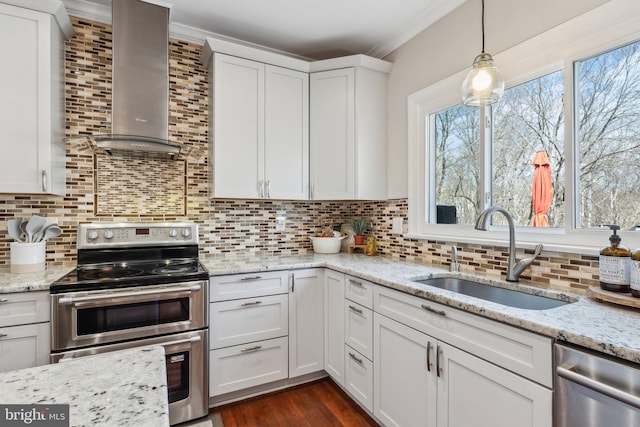 kitchen featuring backsplash, crown molding, stainless steel appliances, wall chimney exhaust hood, and a sink