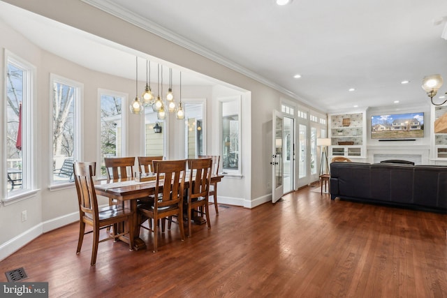 dining space with visible vents, baseboards, dark wood finished floors, and crown molding