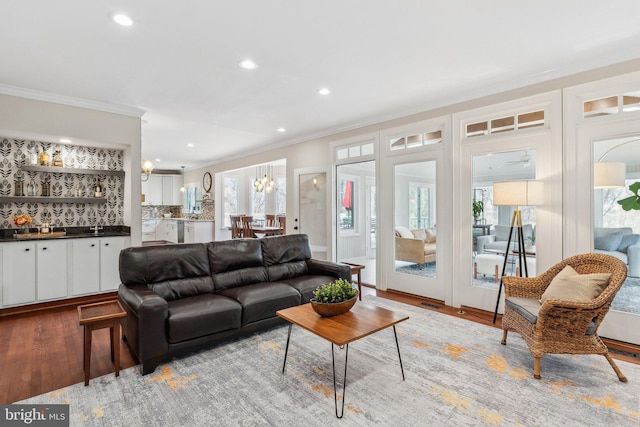 living room featuring recessed lighting, wood finished floors, and crown molding