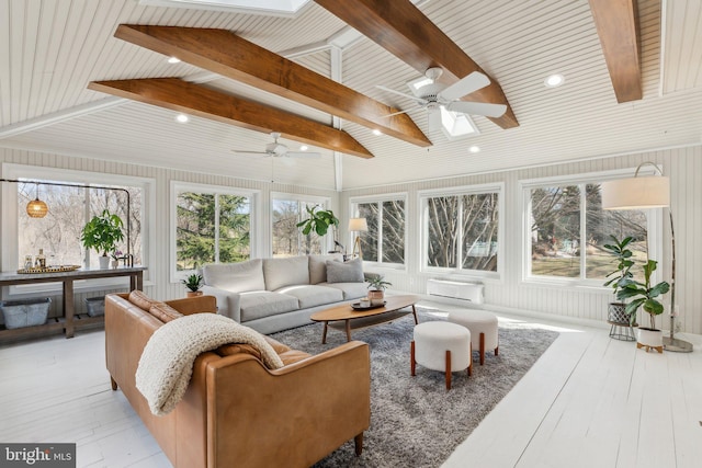 sunroom / solarium featuring lofted ceiling with skylight, a healthy amount of sunlight, and ceiling fan